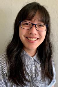 A smiling woman with long hair and glasses